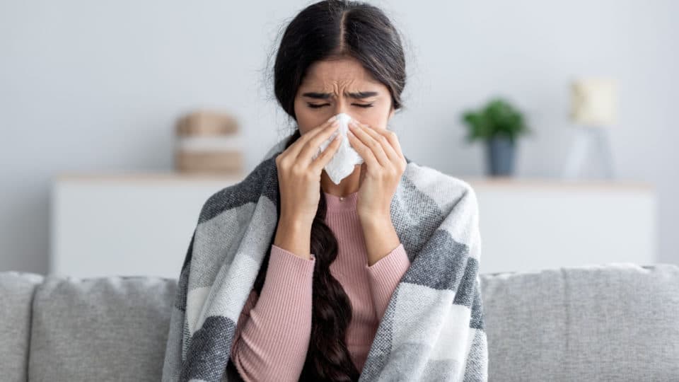 Mulher com sintomas de gripe indicando que o vírus pode causar a nova pandemia .