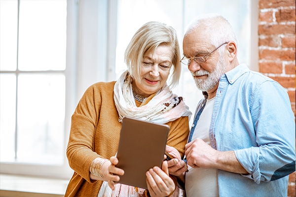 idosos com um tablet consultando seus direitos