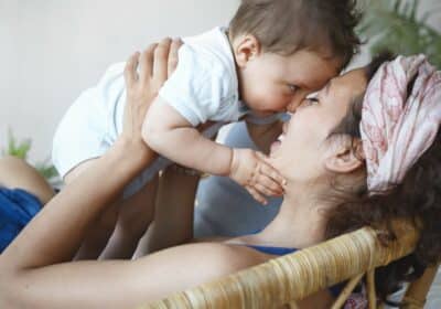 Mulher com seu filho feliz por ter o novo auxílio para mães solteiras .