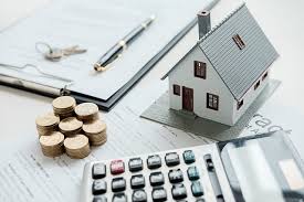 miniatura de uma casa ao lado de uma calculadora, moedas caneta e papel, representando iptu