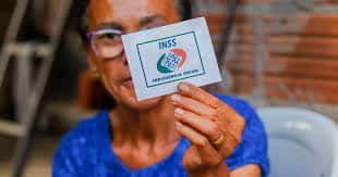 mulher segurando um cartão do inss
