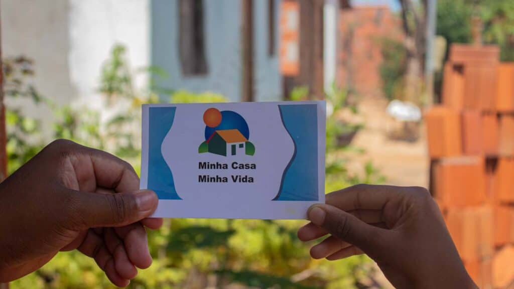 Mão segurando lembrete do Minha Casa Minha Vida, programa criado pelo Lula