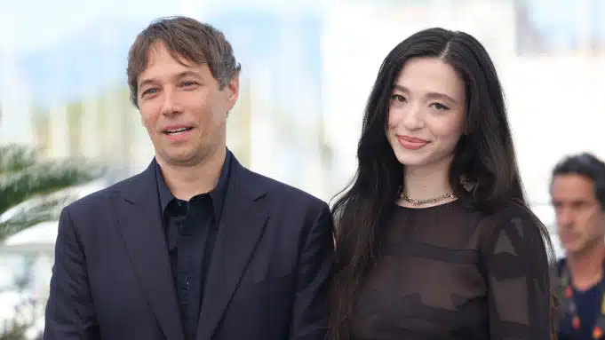 Fotografia de Bean e Madison posando para fotos durante o Festival de Cannes. Ambas estão sorrindo para a câmera e usando roupas pretas