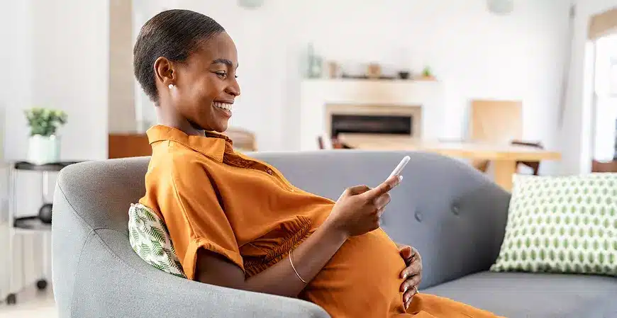 mãe que é mei grávida vendo no celular sobre o auxílio-maternidade