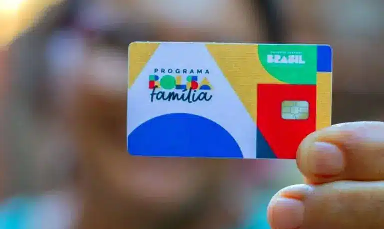 pessoa segurando cartão colorido do bolsa família