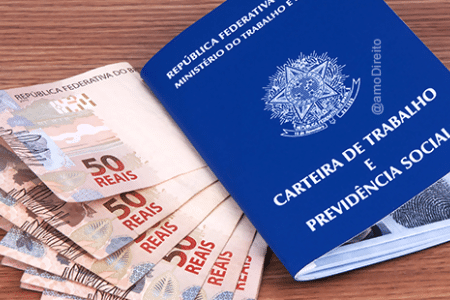 carteira de trabalho ao lado de notas de 10 reais