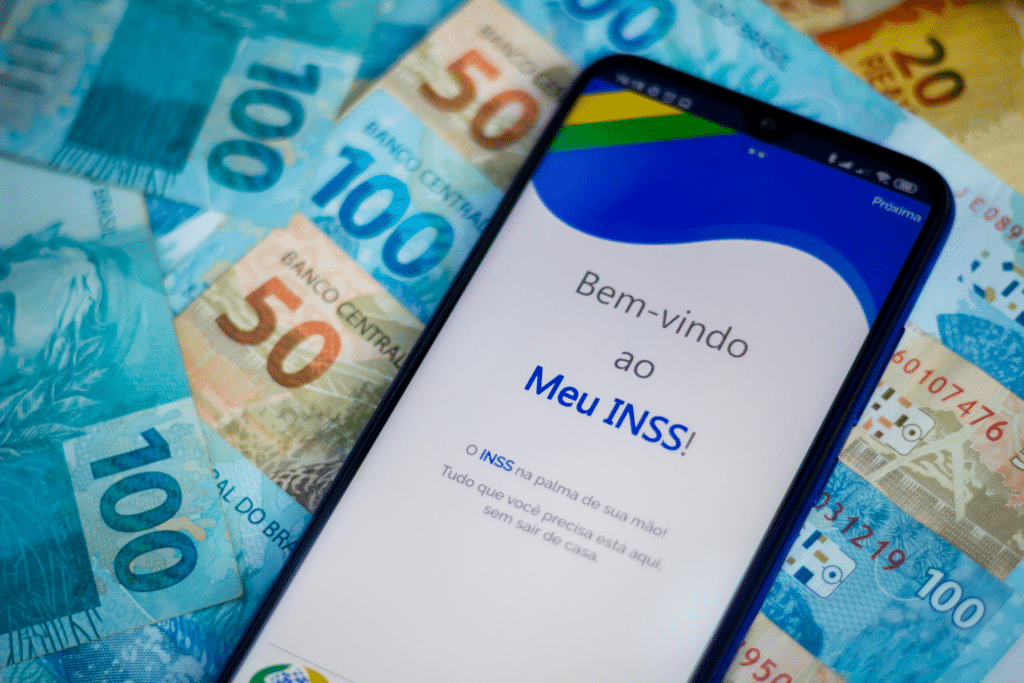 celular com aplicativo do meu inss e cédulas de dinheiro
