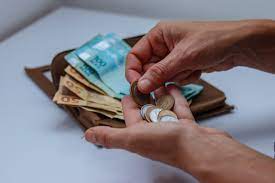 notas de cem e cinqueta reais, mais moedas para indicar Quando começa o pagamento dos aposentados e pensionistas do INSS acima do piso salarial