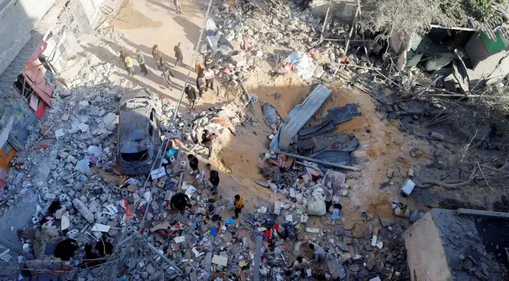 Palestinos examinam o local de um ataque israelense a uma residência em Rafah, no sul da Faixa de Gaza.





