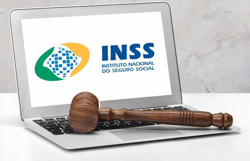 martelo em cima do notebook aberto no site do inss