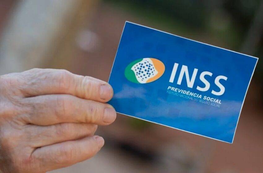 mão de aposentado segurando cartão do inss