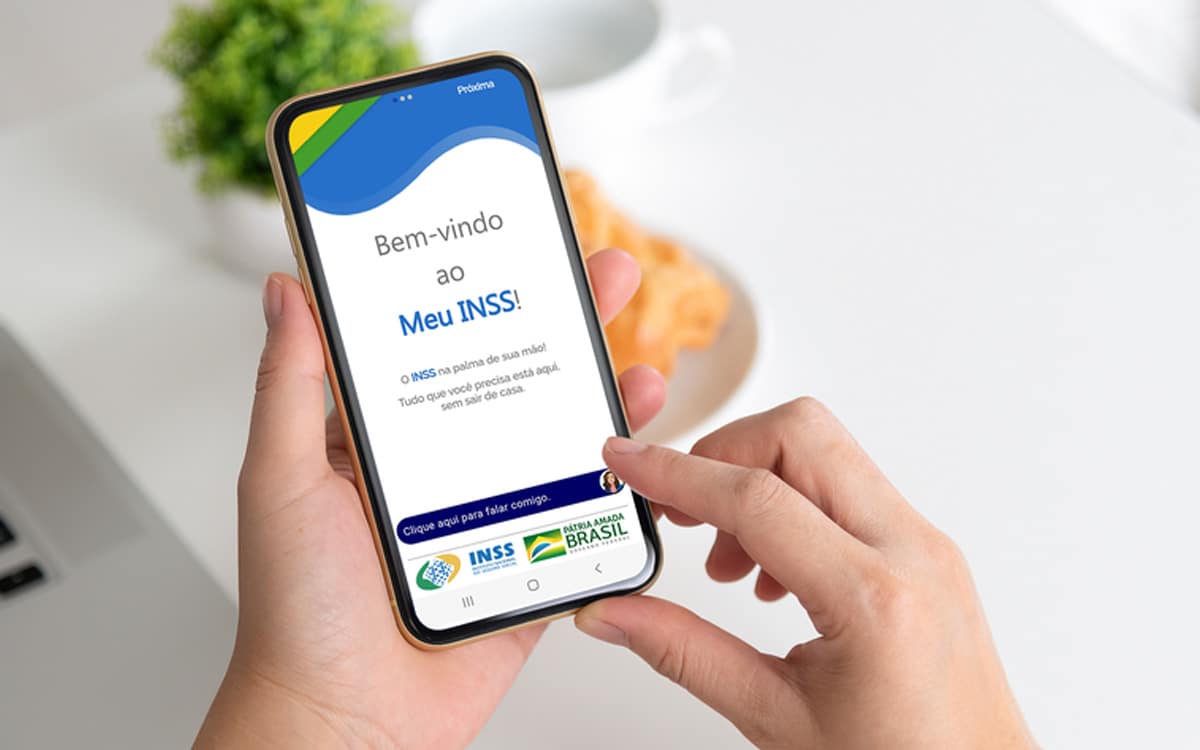 mãos segurando smartphone com aplicativo meu inss aberto