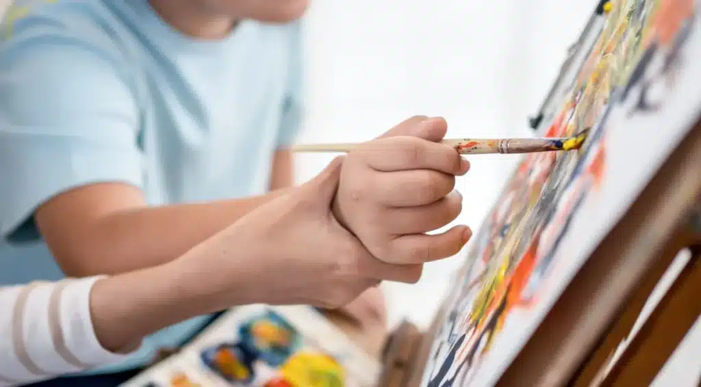 Criança com autismo pintando quadro. (Fonte: Athima Tongloom/ Getty Images)