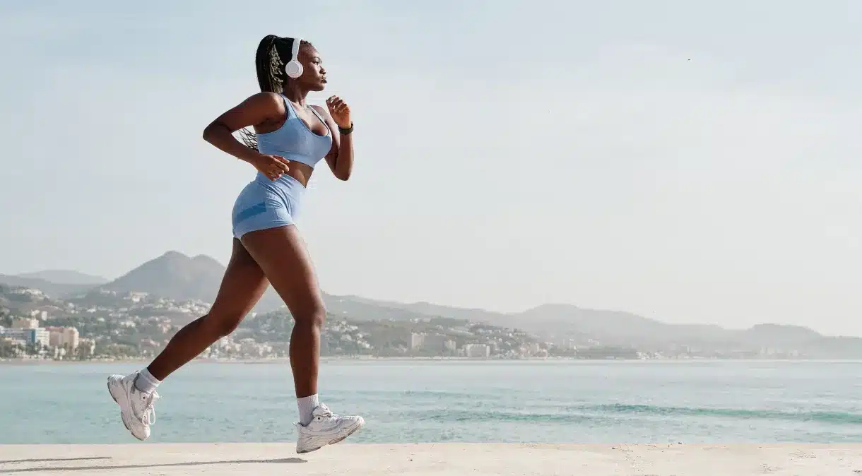 mulher fazendo corrida na orla da praia