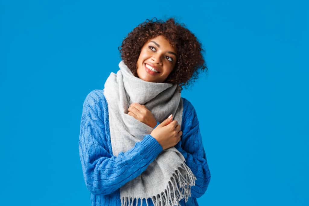 Mulher com roupa de frio e cachecol no inverno. (Fonte: Reprodução Freepik).