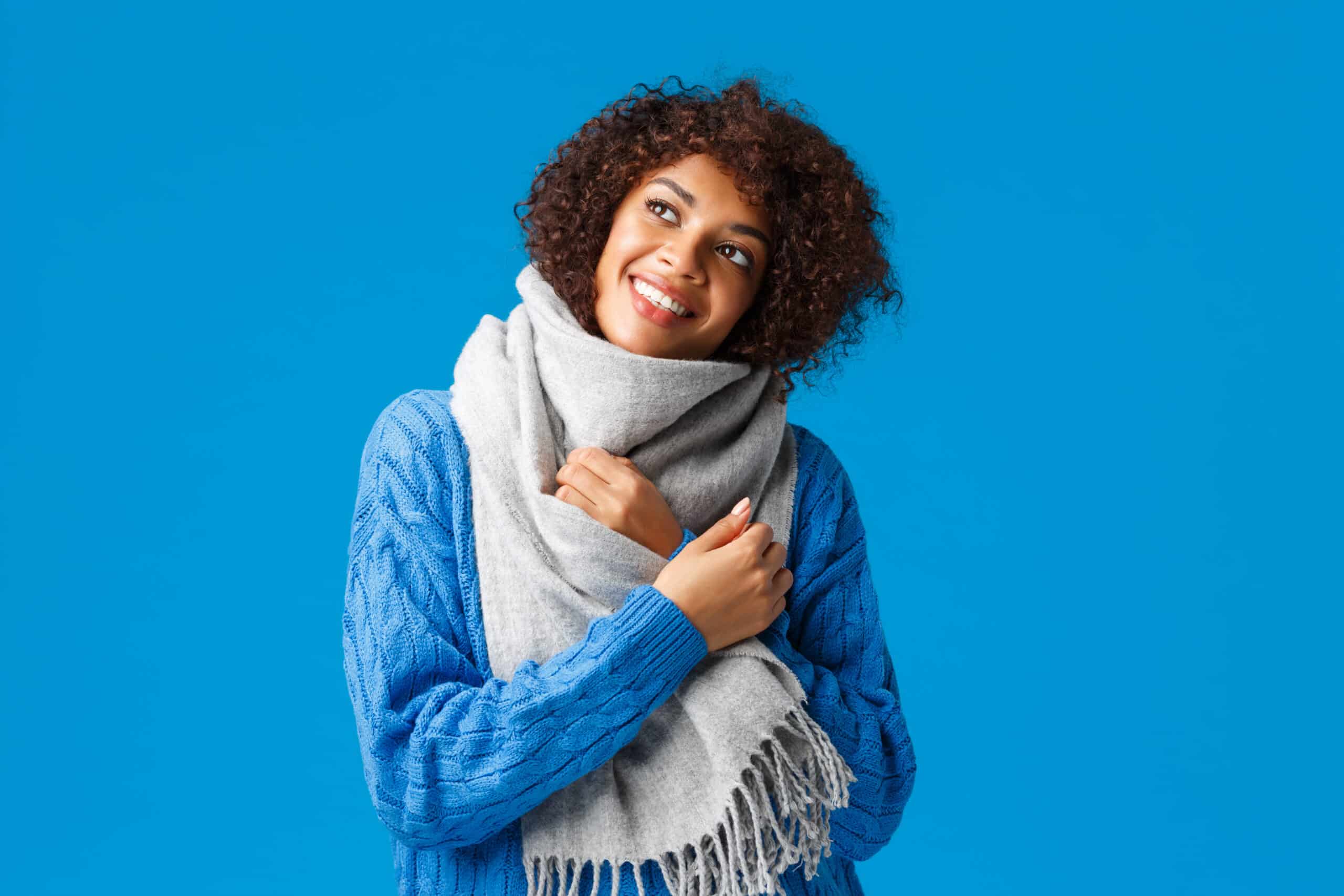 Mulher com roupa de frio e cachecol no inverno. (Fonte: Reprodução Freepik).