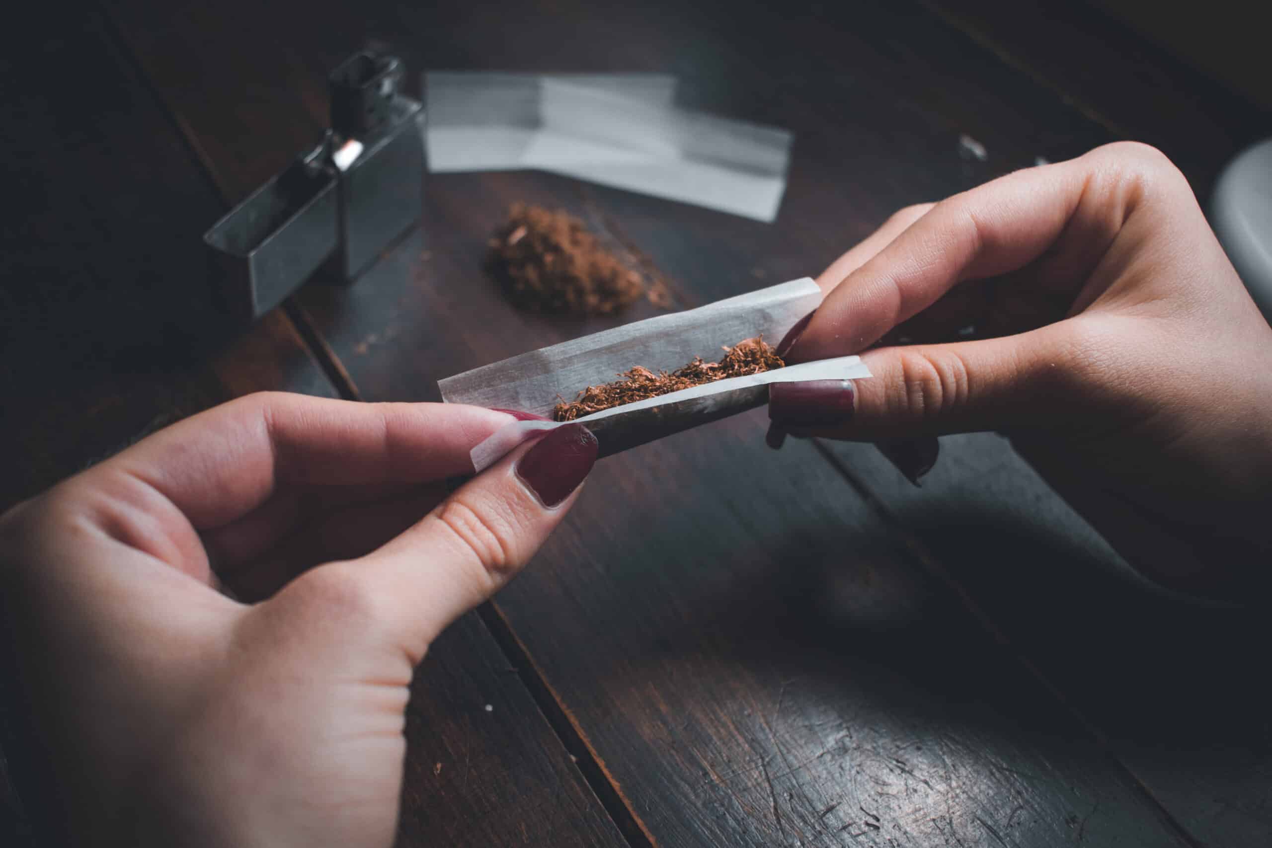 mão bolando maconha