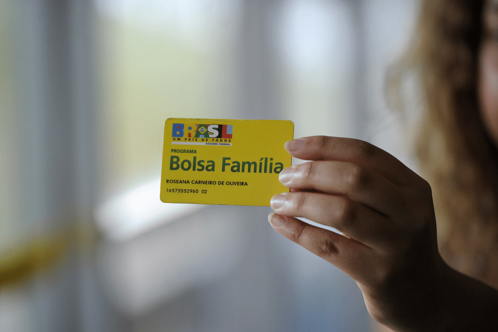 mao feminina segurando cartao do bolsa familia