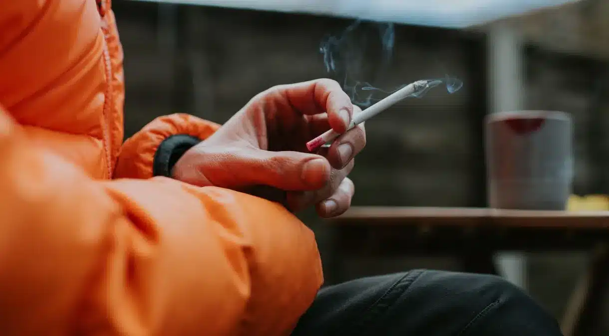 pessoa segurando cigarro