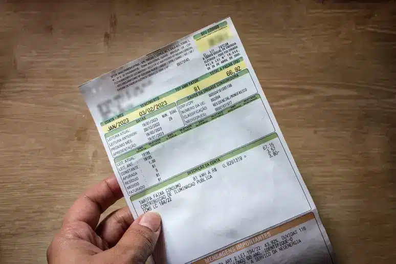 mão segurando conta de luz