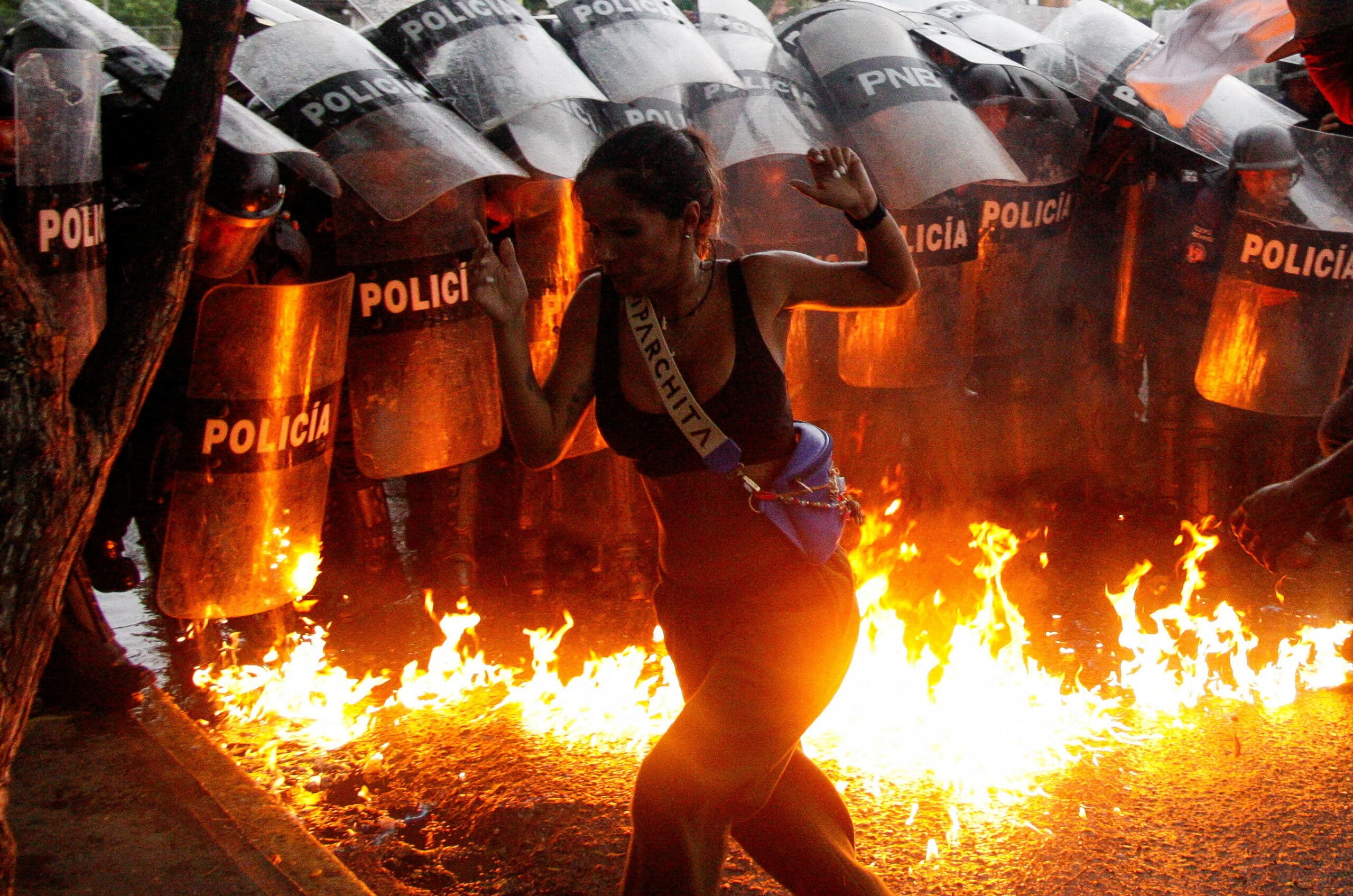 Pessoas em meio ao fogo protestando contra Maduro, reeleito na Venezuela. (Fonte: Jornal Nexo).
