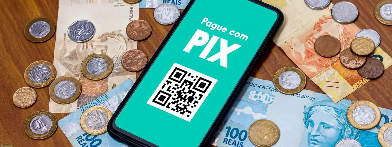 pix no celular e dinheiro ao lado