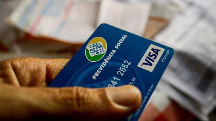 mão segurando cartão do inss