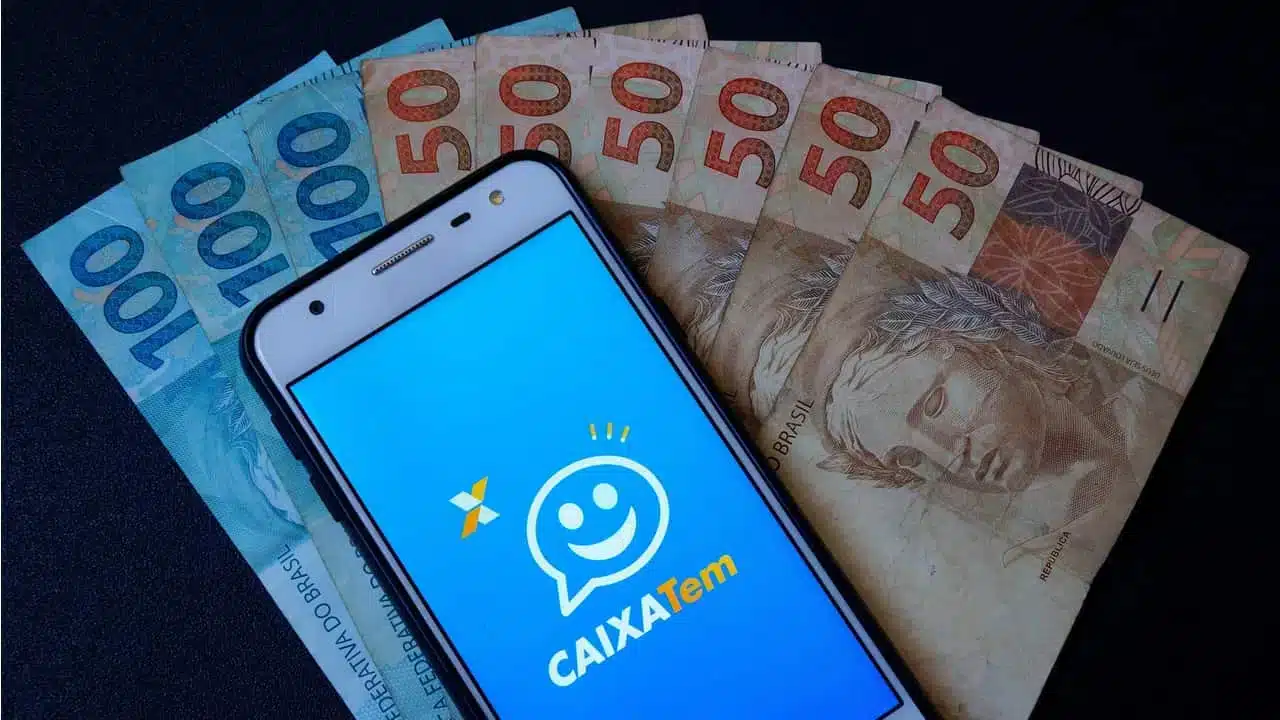 celular no caixa tem ao lado de dinheiro