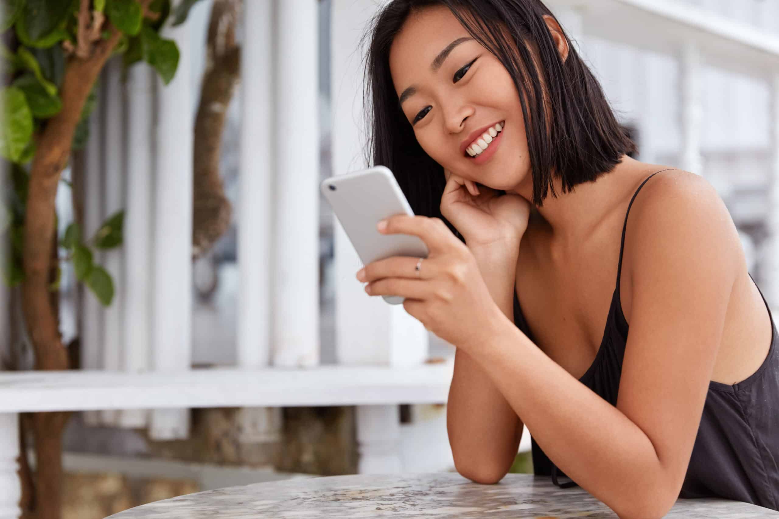 mulher feliz. mexendo no celular