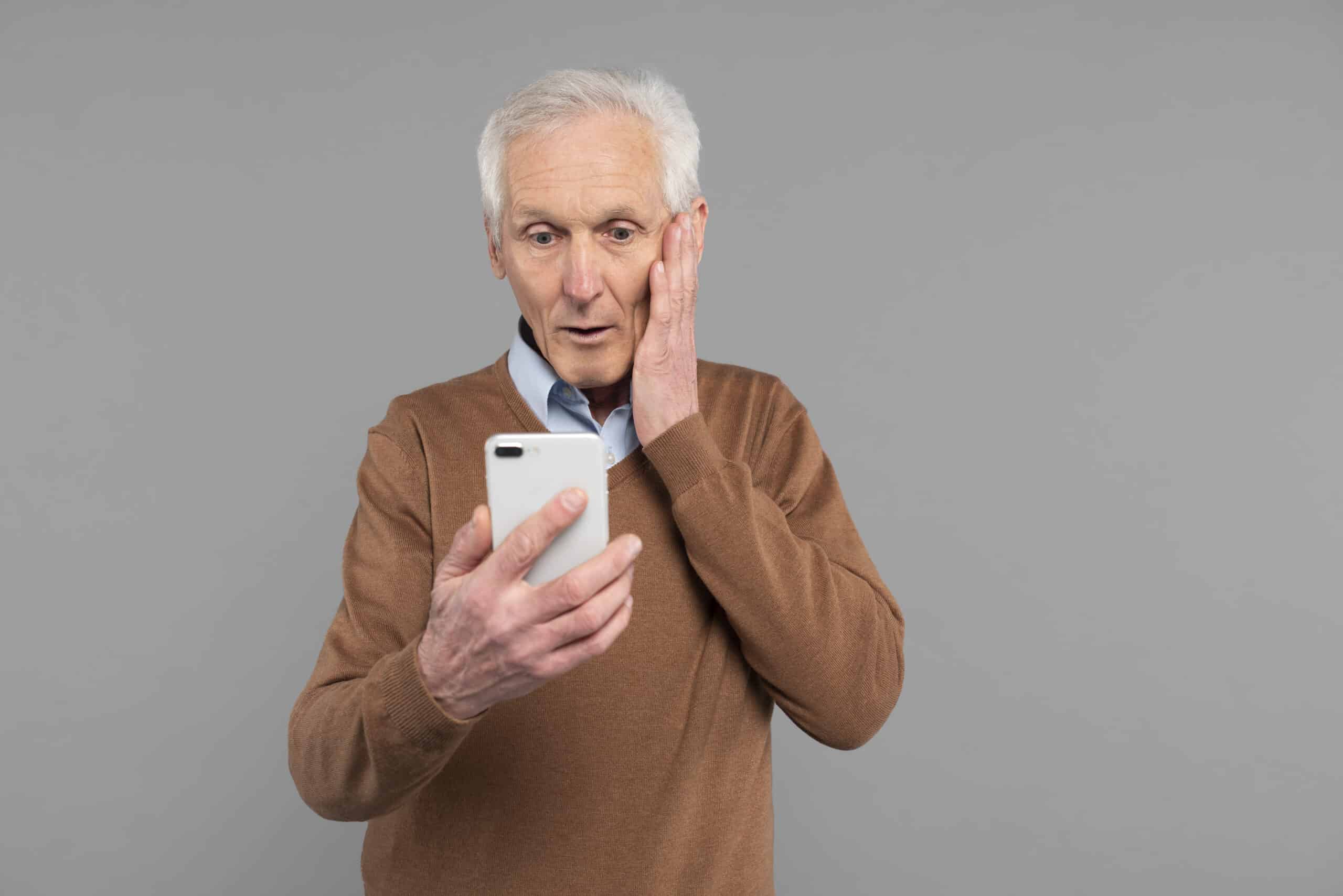 Aposentado do INSS lendo notícia no celular. (Fonte: Freeepik).