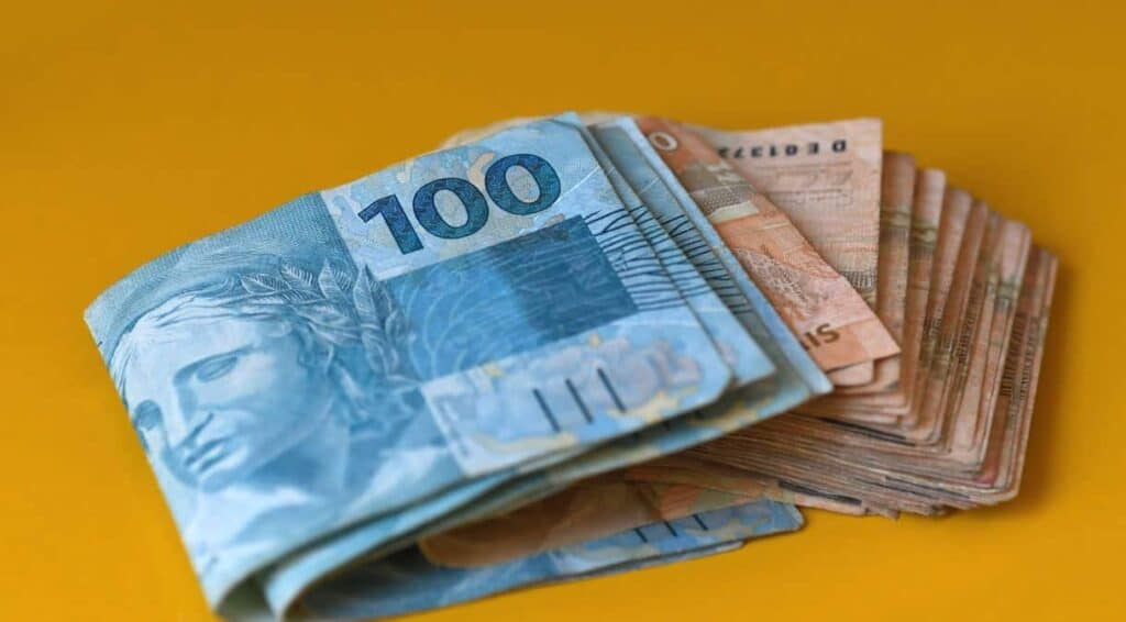 Pagamento do INSS em notas de 100 e 50 reais. (FONTE: shutterstock).
