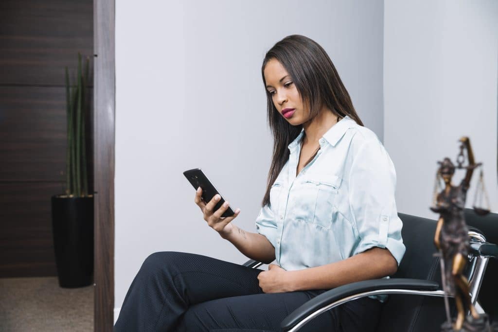 Pessoa com cadeiras de roda no celular verificando cortes do BPC pelo INSS. (Fonte: freepik).