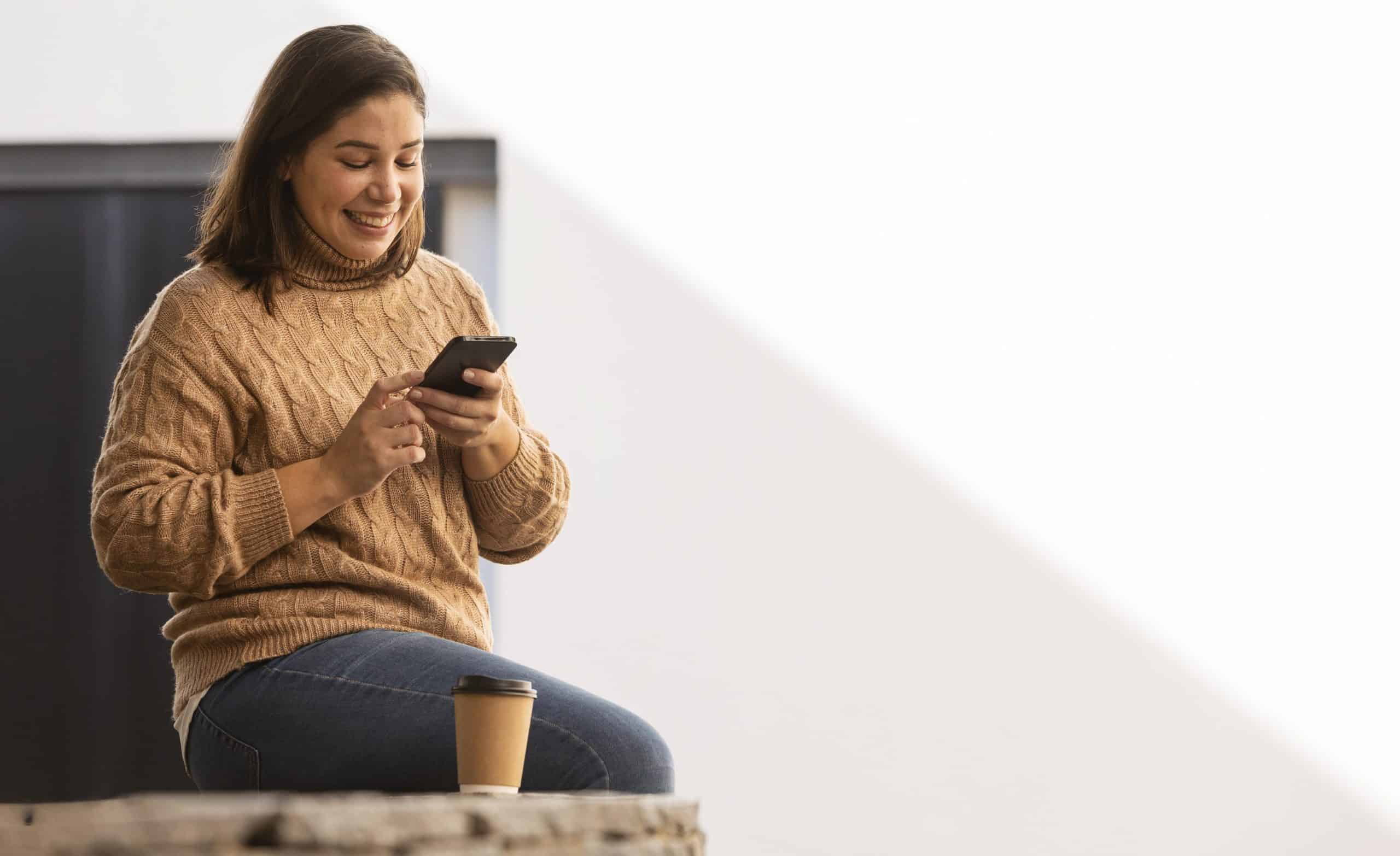 Mulher no celular vendo notícia de como receber dinheiro do governo por meio do cadúnico. (Fonte: freepik).
