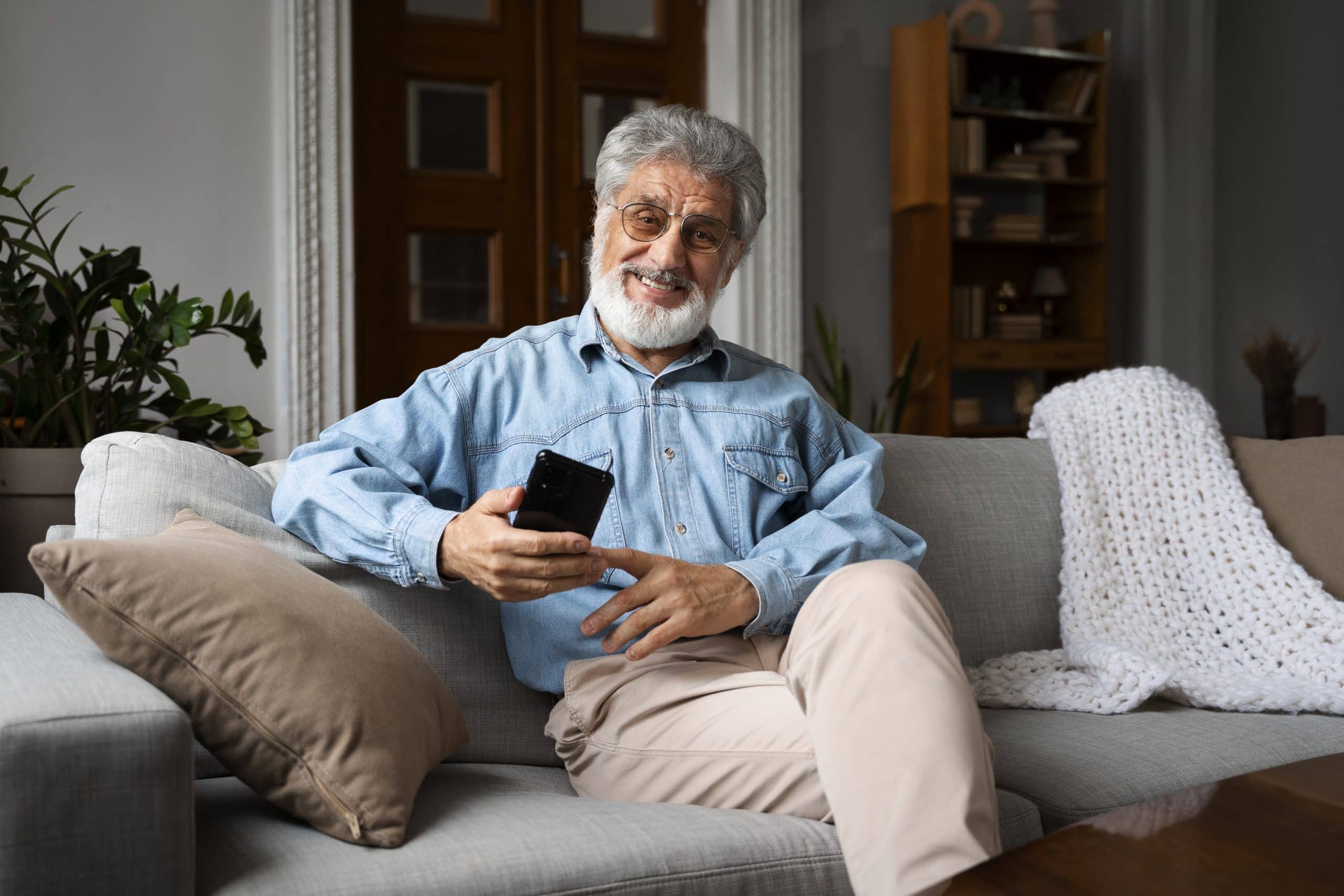 Idoso no celular feliz com dívidas que ele não precisa mais pagar.