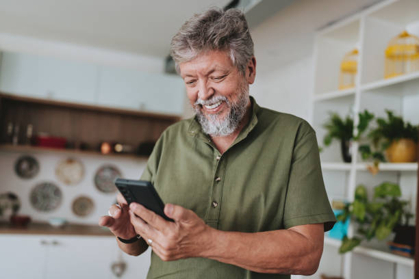 Aposentado do INSS olhando no celular como excluir consignado. (Fonte: iStock).
