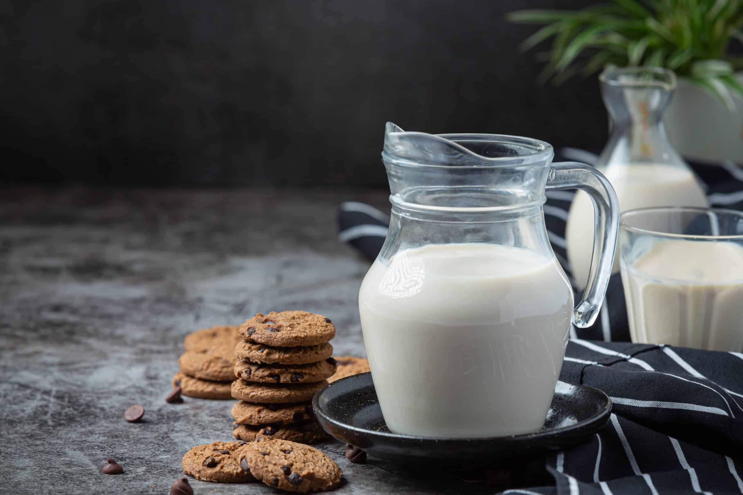 jarra de leite ao lado de cookies